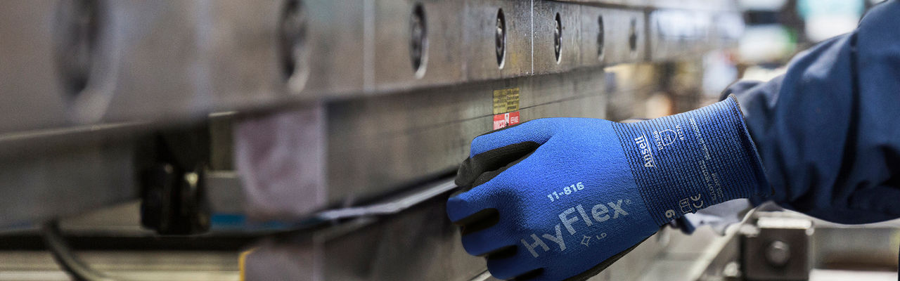 Hispanic worker fabricating metal in factory